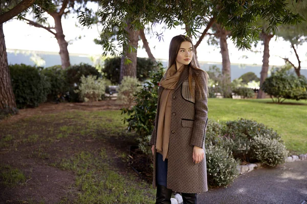 Baharda bahçede poz veren uzun saçlı genç kız.