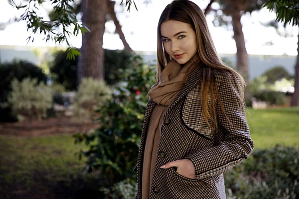 Baharda bahçede poz veren uzun saçlı genç kız.