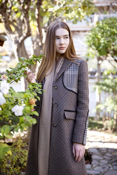 Baharda bahçede poz veren uzun saçlı genç kız.