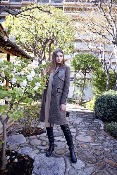 Baharda bahçede poz veren uzun saçlı genç kız.