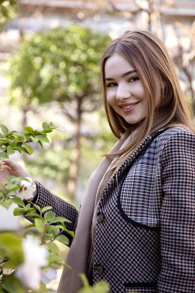 Baharda bahçede poz veren uzun saçlı genç kız.