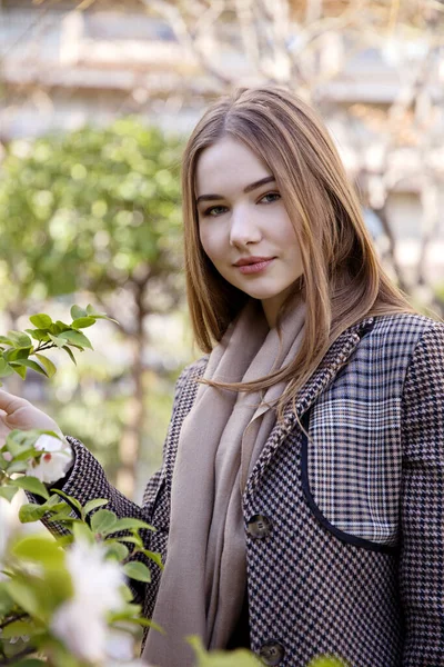 Baharda bahçede poz veren uzun saçlı genç kız.