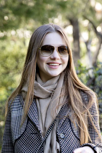 Baharda bahçede poz veren uzun saçlı genç kız.