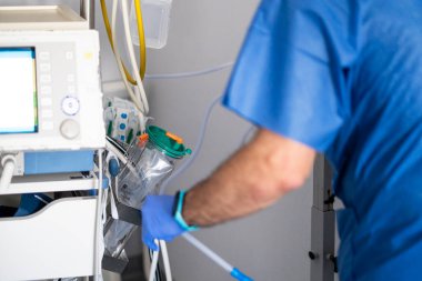 Doctor adjusting medical equipment while working in a hospital operating room