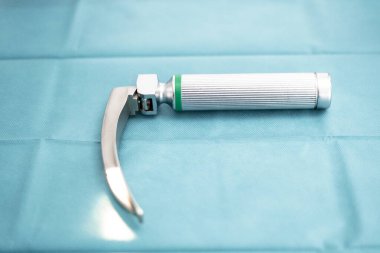 Tıbbi laringoskop mavi cerrahi bir perdeye yerleştirildi. Hastane ameliyathanesinde entübasyon işlemi için hazır.