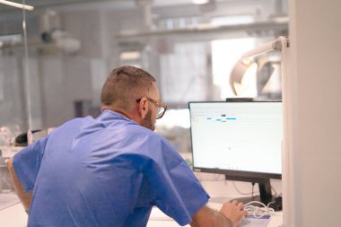 Man in medical scrubs using computer in a science laboratory