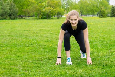 Sevimli, mutlu bir kız koşmaya hazırlanıyor. Başlangıç pozu