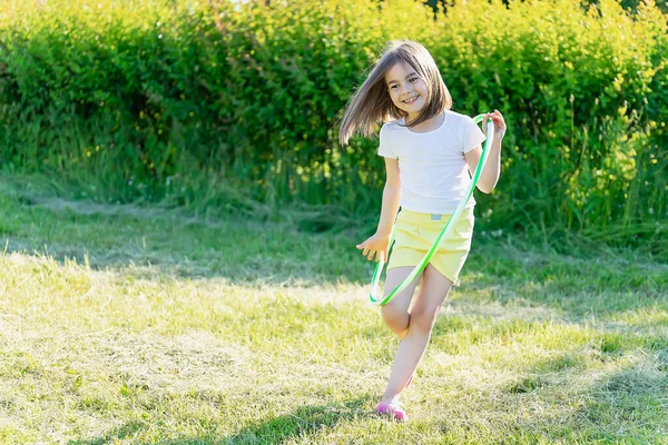 Parkta spor yapan küçük bir kız. Hulahup Oyunları