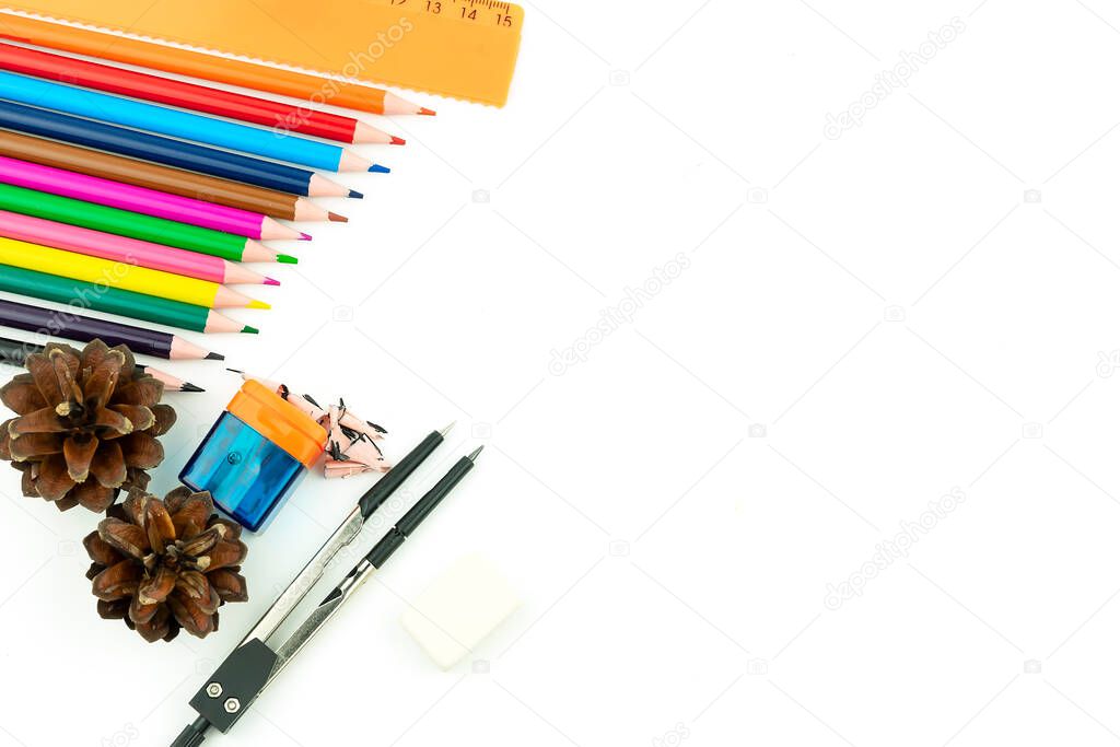 Multi-colored pencils, eraser, ruler, sharpener and compasses on a white background. Copyspace