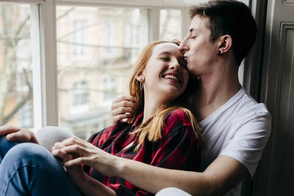 Young Man Kissing Blonde Girlfriend Foreground Window — Stock Photo, Image