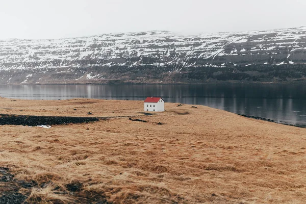 Avlägsna hus på terräng sjön kuststräcka — Stockfoto