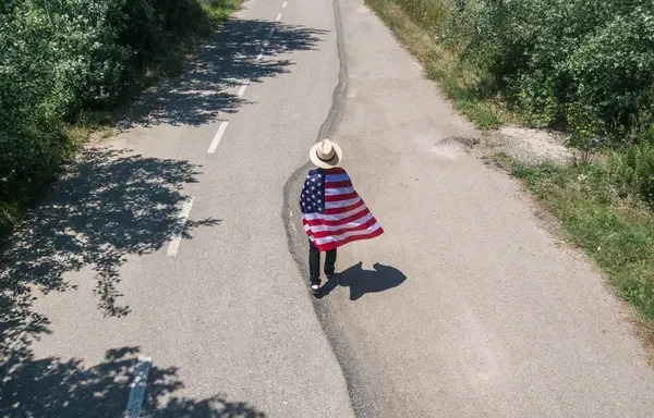 Mand i hat gå med amerikansk flag - Stock-foto
