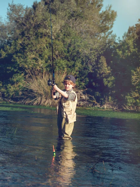 Маленький хлопчик риболовля в річці — стокове фото