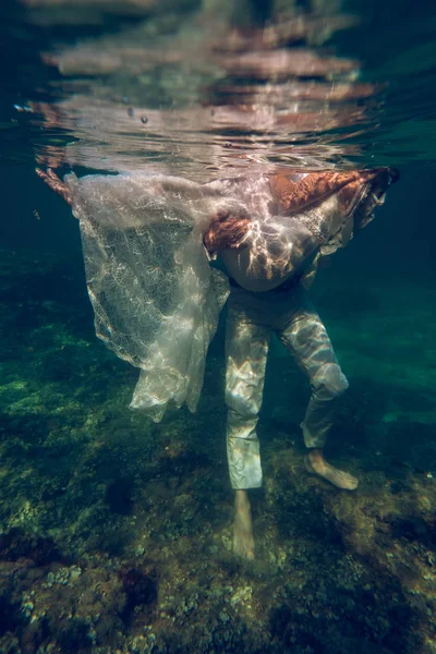 Çıplak Ayaklı Bir Adam Deniz Suyunda Dikilirken Beyaz Elbiseli Tanınmayan — Stok fotoğraf