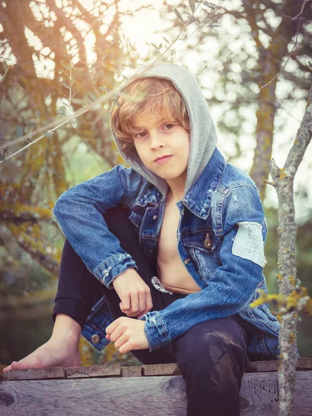Petit garçon assis sur une jetée en bois — Photo