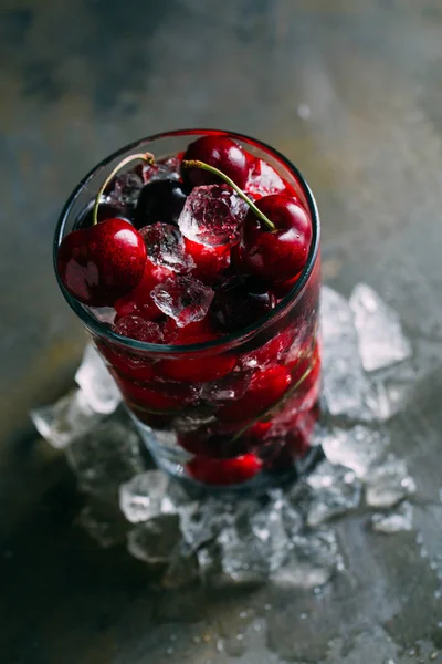 Fresh cherries in glass with ice — Stock Photo, Image