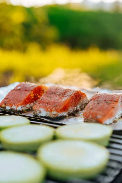 户外烧烤网格上贴箔的鲑鱼和西葫芦片 — 图库照片