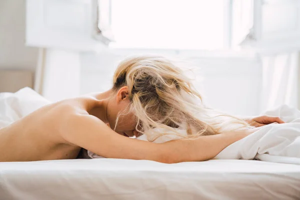 裸体金发女子躺在舒适的床上在舒适的卧室 — 图库照片
