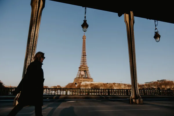 在法国巴黎埃菲尔铁塔的背景下走在大街上的妇女侧视图 — 图库照片