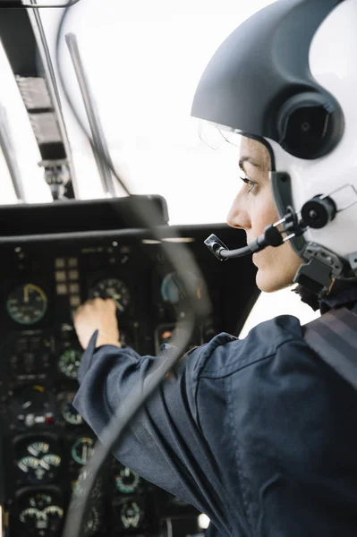 Fokuseret Kvindelig Pilot Siddende Opererer Helikopter - Stock-foto