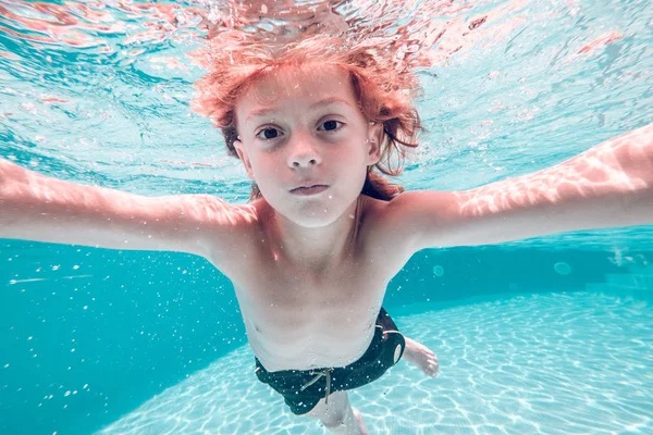 赤髪の子水に潜ると 透明な水の背景にカメラ目線 — ストック写真