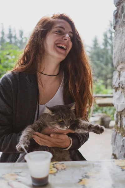 스러운 귀엽게 고양이를 웃으면서 발칸반도의 불가리아 근처에 테이블에 — 스톡 사진