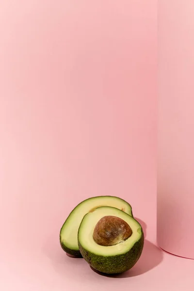 Aguacate Fresco Cortado Mitad Sobre Fondo Rosa —  Fotos de Stock