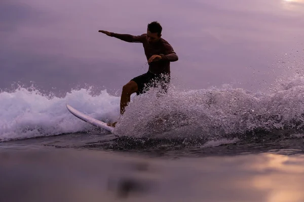 Mężczyzna Surfing Między Falującą Wodą Morską Plamami Zachmurzonym Niebem Wieczorem — Zdjęcie stockowe