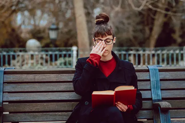 Jovem Mulher Elegante Óculos Leitura Livro Enquanto Sentado Banco Parque — Fotografia de Stock