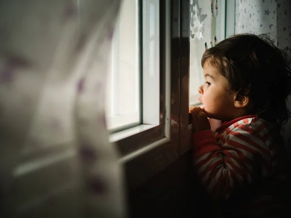 Маленькая Девочка Выглядывает Окна Дома — стоковое фото