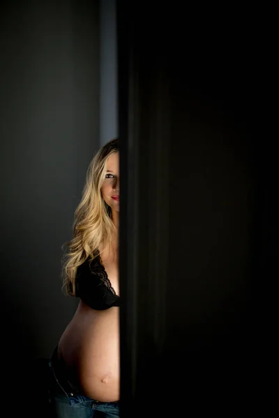 Pregnant Woman Bra Looking Camera While Standing Open Door Dark — Stock Photo, Image