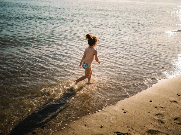 Vista Trasera Niña Linda Anónima Deslizamientos Natación Corriendo Playa Arena — Foto de Stock