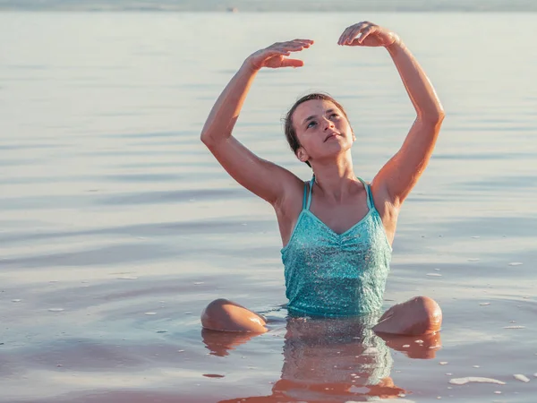 Вдумчивая Девушка Сидит Воде Поднятыми Руками Смотрит Вверх — стоковое фото