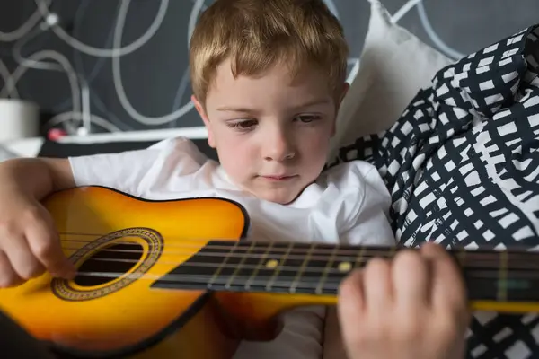 Young Blonde Boy Playing Toy Guitar — Stock Photo, Image