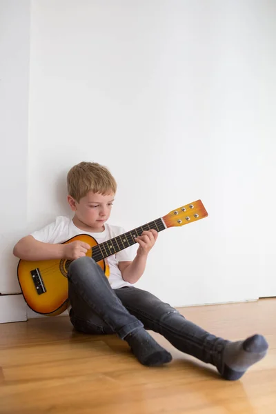 Young Blonde Boy Playing Toy Guitar — Stock Photo, Image