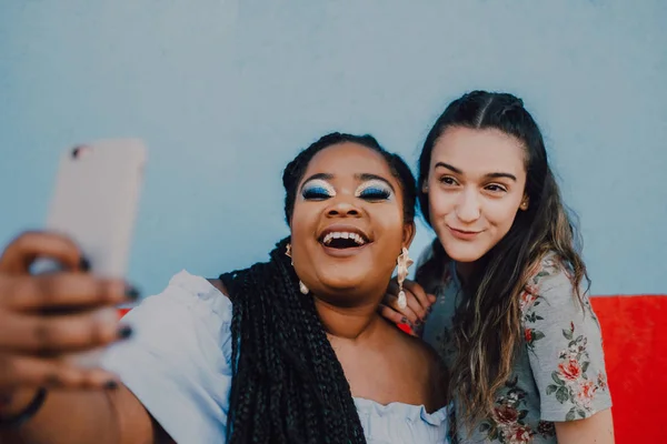 多人種の若いカジュアルな女性たちが笑顔でスマホで自撮りし — ストック写真