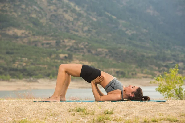 Mid Adult Woman Bridge Pose Doing Yoga Outdoors Dam Beach — Stock Photo, Image