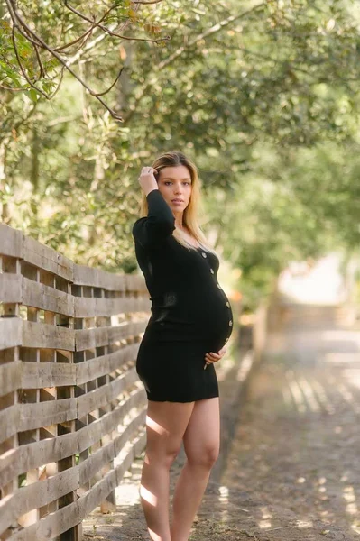 Zwangere Vrouw Zoek Naar Camera Het Aanraken Van Buik Terwijl — Stockfoto