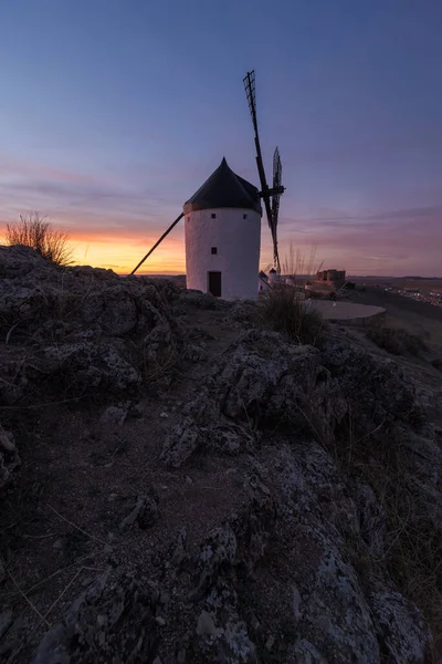 古老的风车坐落在中世纪城堡附近的岩石悬崖上 与乡间阴沉沉的落日相比 — 图库照片