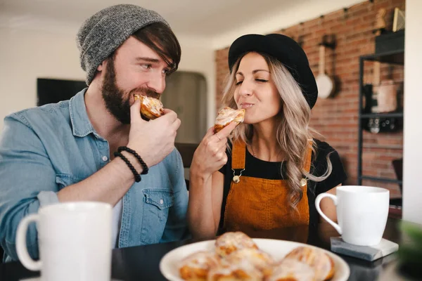 Socios Felices Ropa Casual Mirándose Mientras Comen Rollos Dulces Con — Foto de Stock