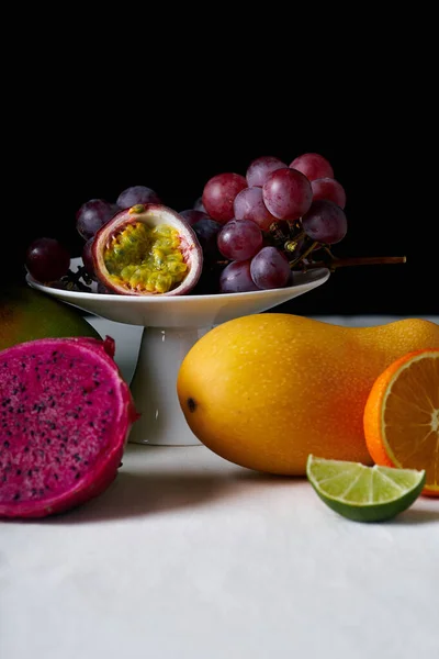 Bodegón Con Frutas Tropicales Sobre Mantel Blanco Fondo Oscuro — Foto de Stock