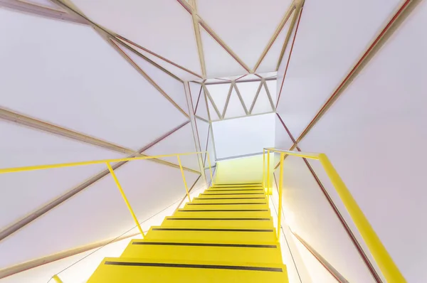 壁や天井の幾何学的要素に囲まれた黄色の階段の上から — ストック写真