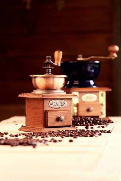 Manuelle Kaffeemühlen Auf Dem Tisch Mit Verstreuten Kaffeebohnen Gemütlichem Café — Stockfoto