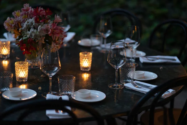 Mesa decorada con velas y flores por la noche - foto de stock