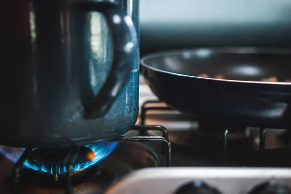 Закрийте велику металеву кухню і смажену сковорідку, підпаливши на кухні газову пічку. — стокове фото