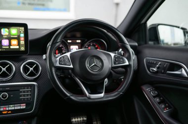 Derby, İngiltere - 19 Eylül 2025: Mercedes-Benz direksiyon simidi, üç köşeli ikonik yıldız logosu, entegre çok fonksiyonlu düğmeler