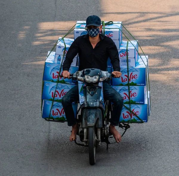 Motosiklet süren ve bir sürü paket taşıyan Vietnamlılar. Bu tipik bir Vietnam taşımacılığı. Motosikleti ya da scooter 'ı var, Hanoi, Vietnam.