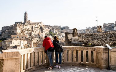 Genç turistler, Güney İtalya 'daki Matera eski kasabasının manzarasına hayran.