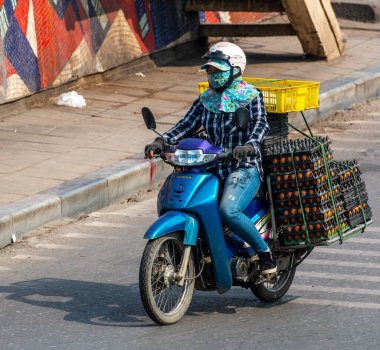  Motosiklet süren ve bir sürü paket taşıyan Vietnamlılar. Bu tipik bir Vietnam taşımacılığı. Motosikleti ya da scooter 'ı var. Vietnam.