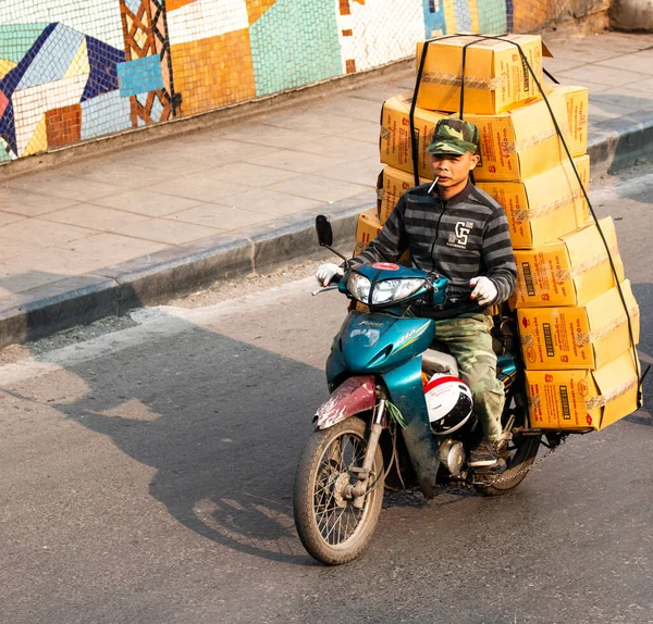  Motosiklet süren ve bir sürü paket taşıyan Vietnamlılar. Bu tipik bir Vietnam taşımacılığı. Motosikleti ya da scooter 'ı var. Vietnam.